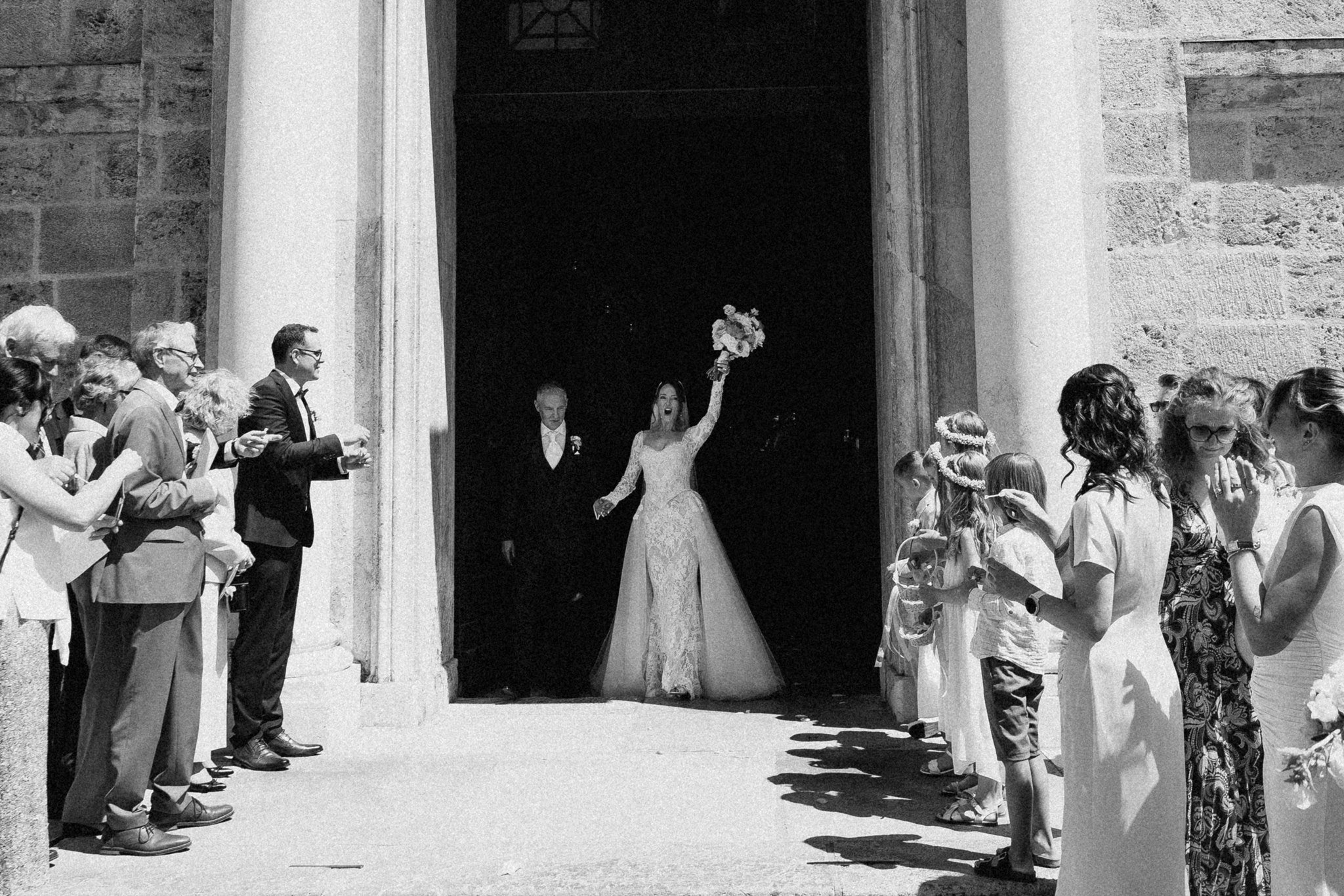 Sophia cheers as she leaves the church with her bouquet raised.