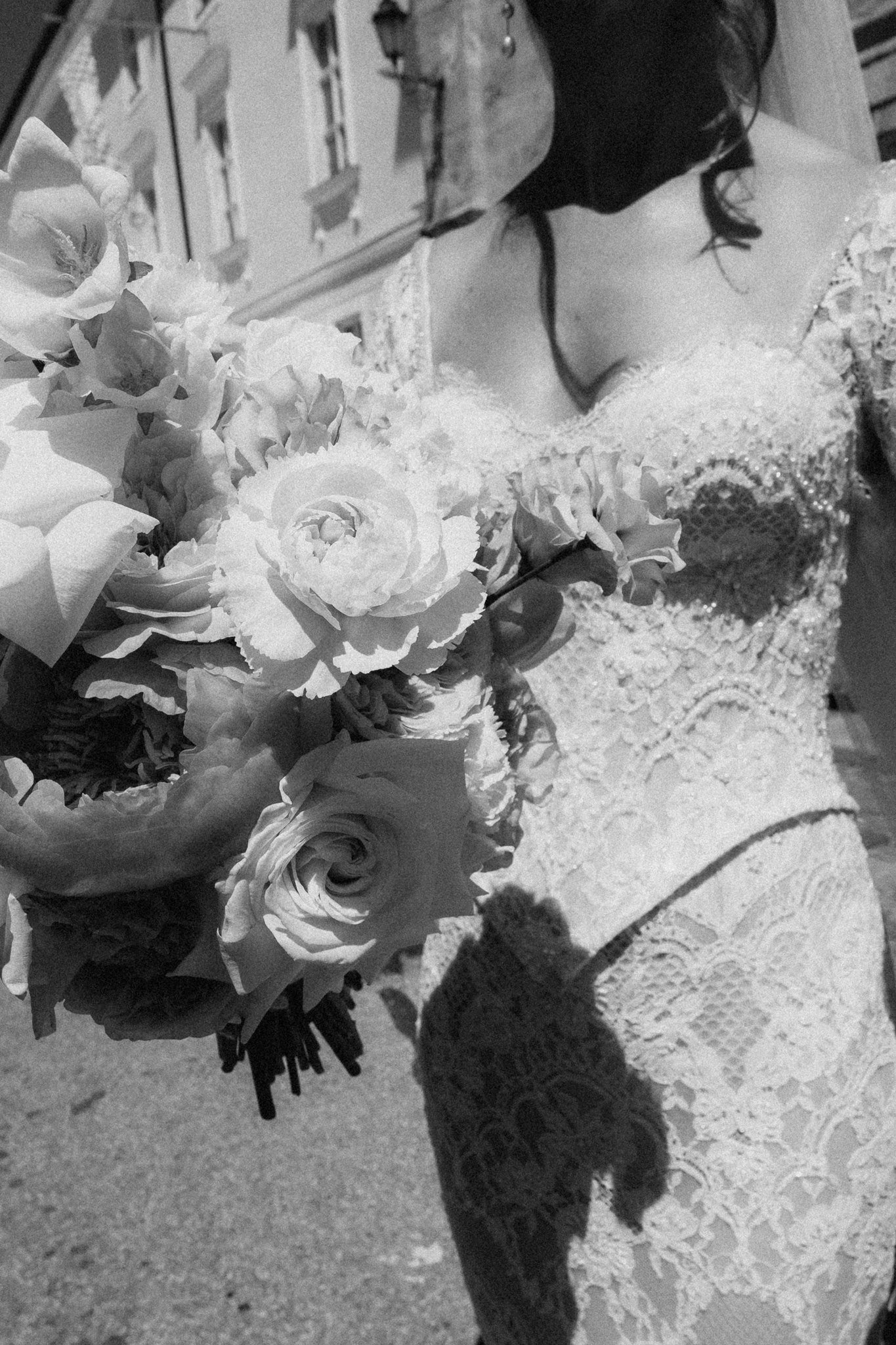 Sophia’s bouquet of roses and ranunculus against her lace dress in black and white.