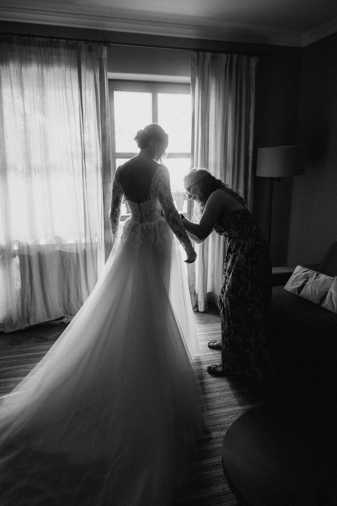 Sophia is helped into her tulle wedding gown in black and white.