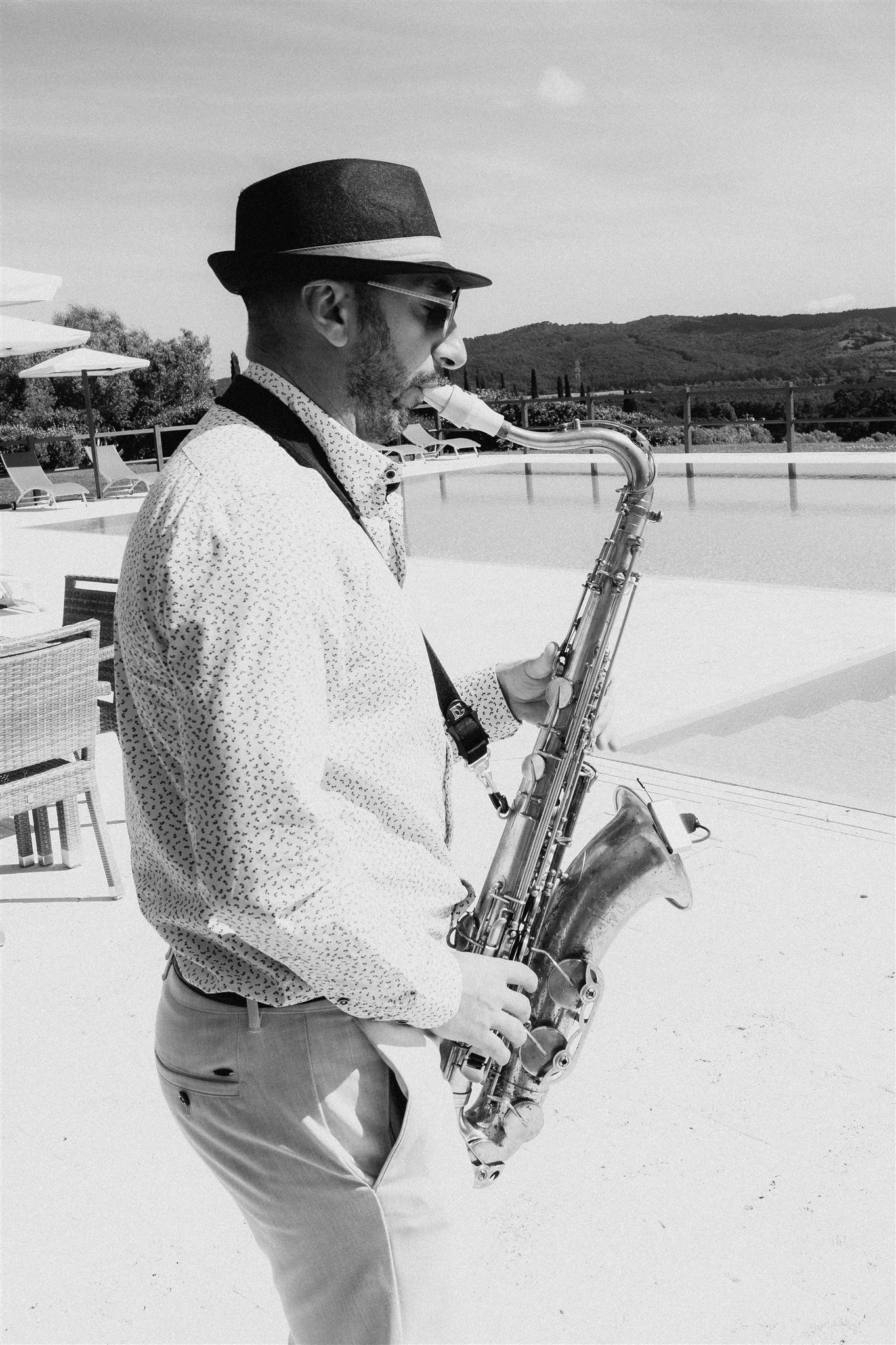 A saxophonist performs beside the pool during the party.