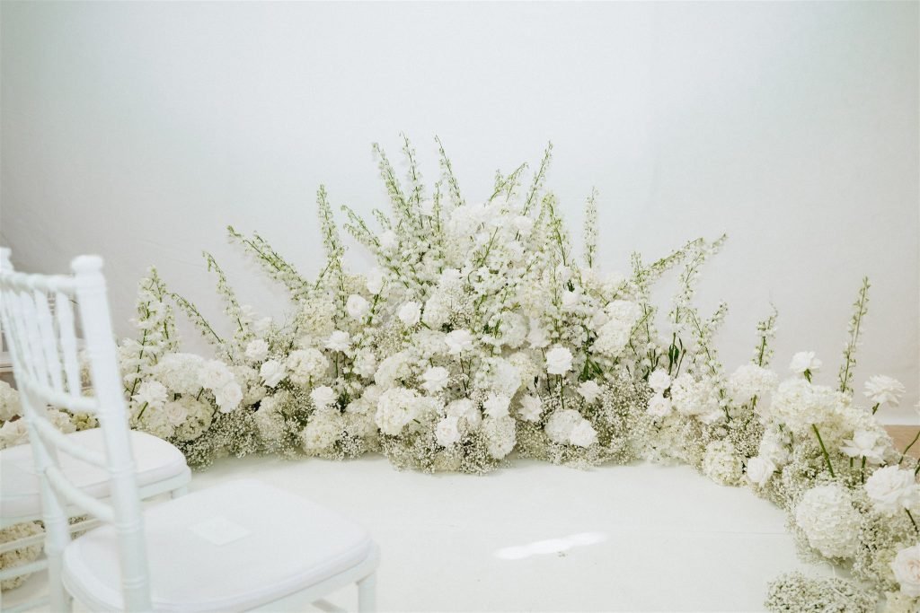 White floral arrangements decorate the ceremony space at Venue 1315.