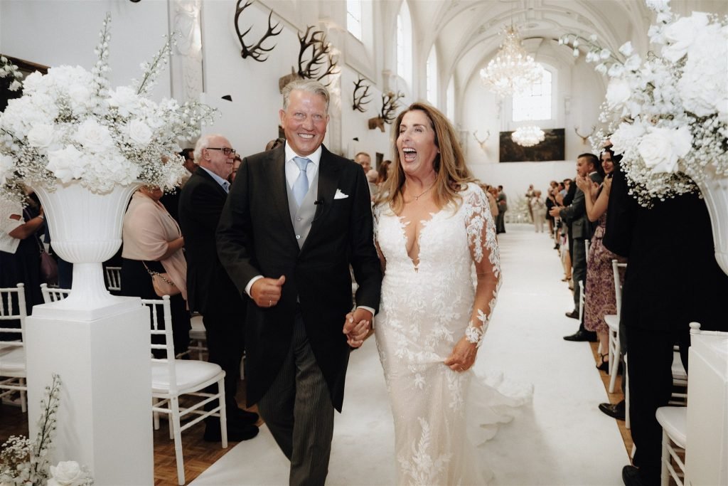 Petra and Dirk walk through the flower lined ceremony aisle at Venue 1315.
