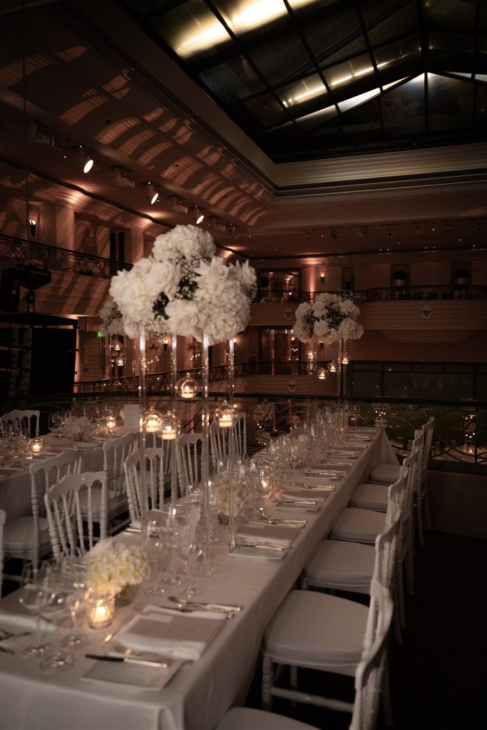 Dinner table with white floral centerpieces in the Bayerischer Hof ballroom.