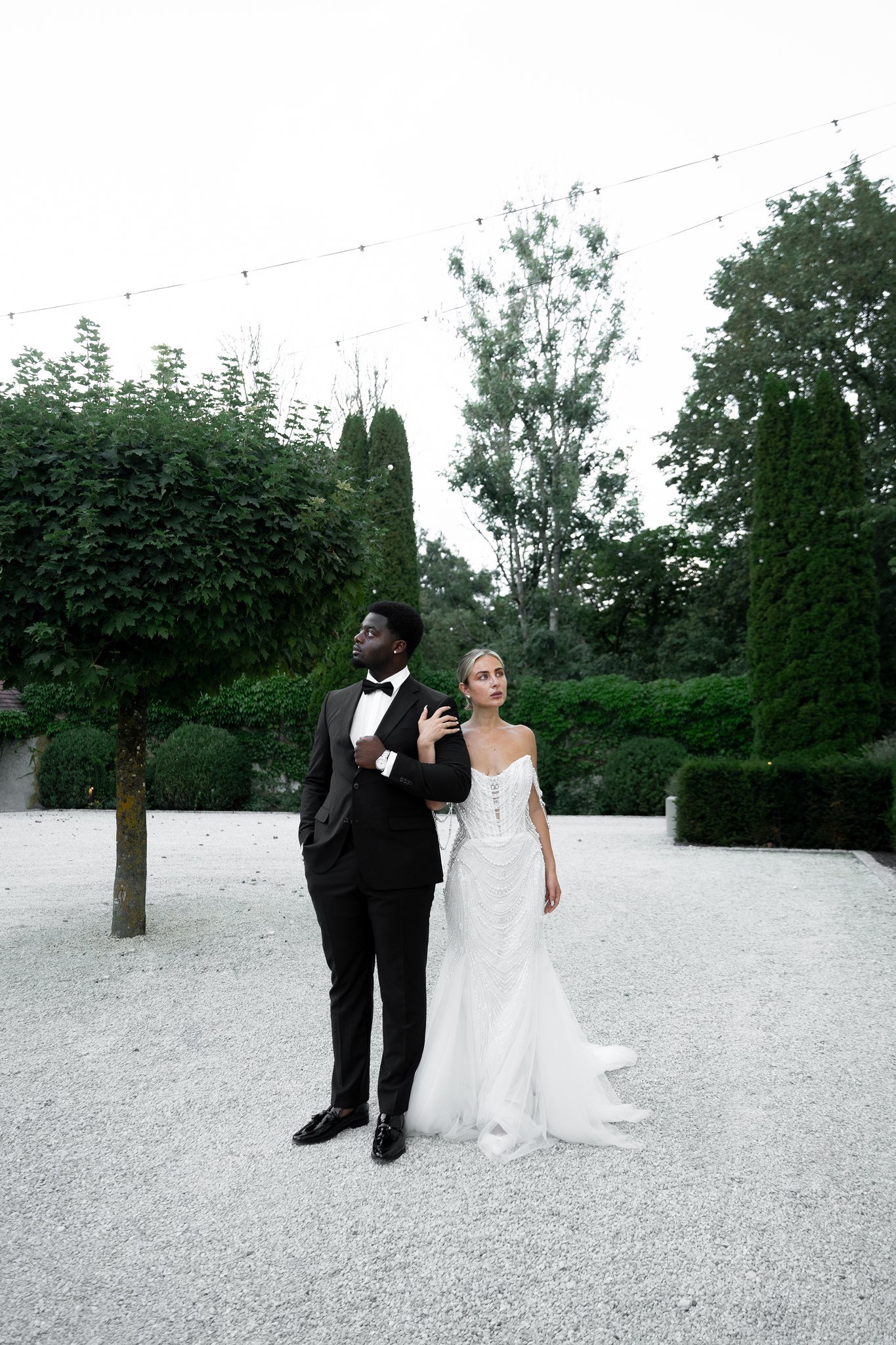 Couple standing in the gravel courtyard of Schloss Duttenstein at dusk