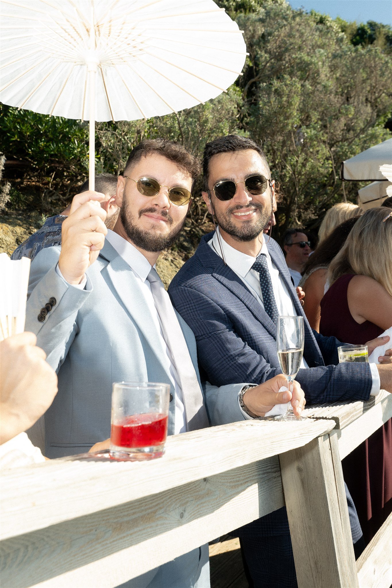 Groomsmen with a parasol at the ocean bar during aperitivo hour