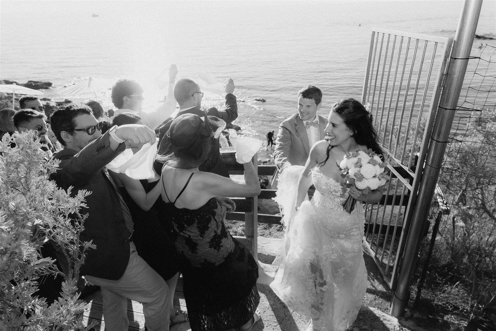 Couple arriving at the beach reception gate backlit by the sun