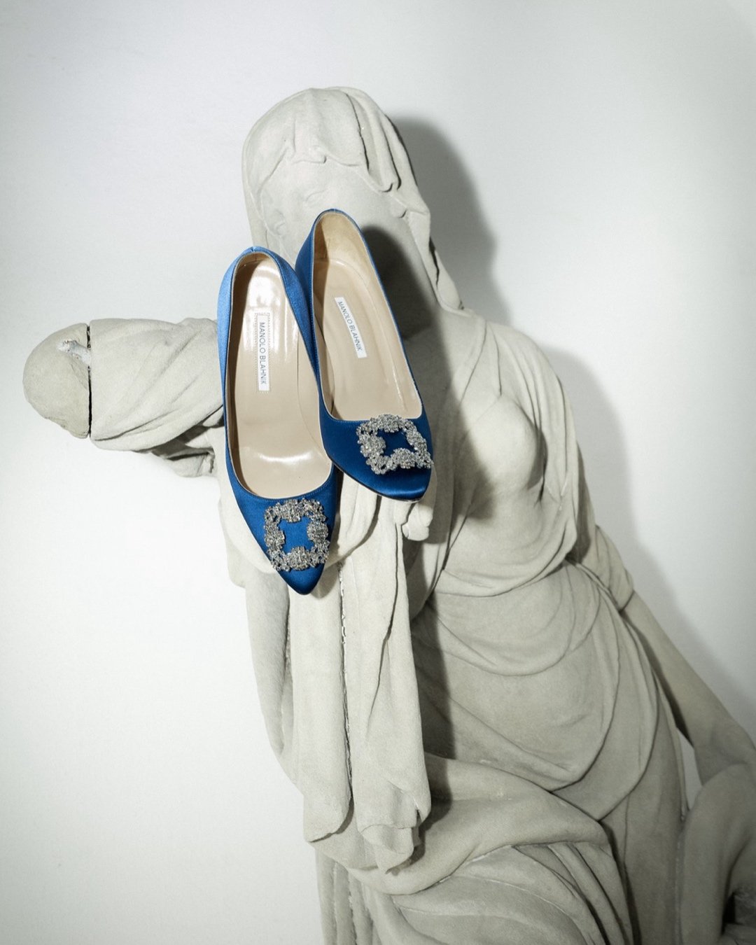 Designer bridal heels posed on a stone statue at Schloss Duttenstein